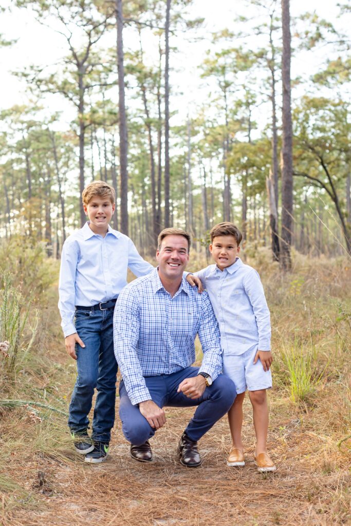 Dad poses with sons in field at Wekiva Springs State Park for their family photos