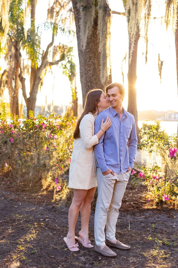 Girl kisses guy after their proposal for their engagement photos at Kraft Azalea Park in Winter Park, Florida